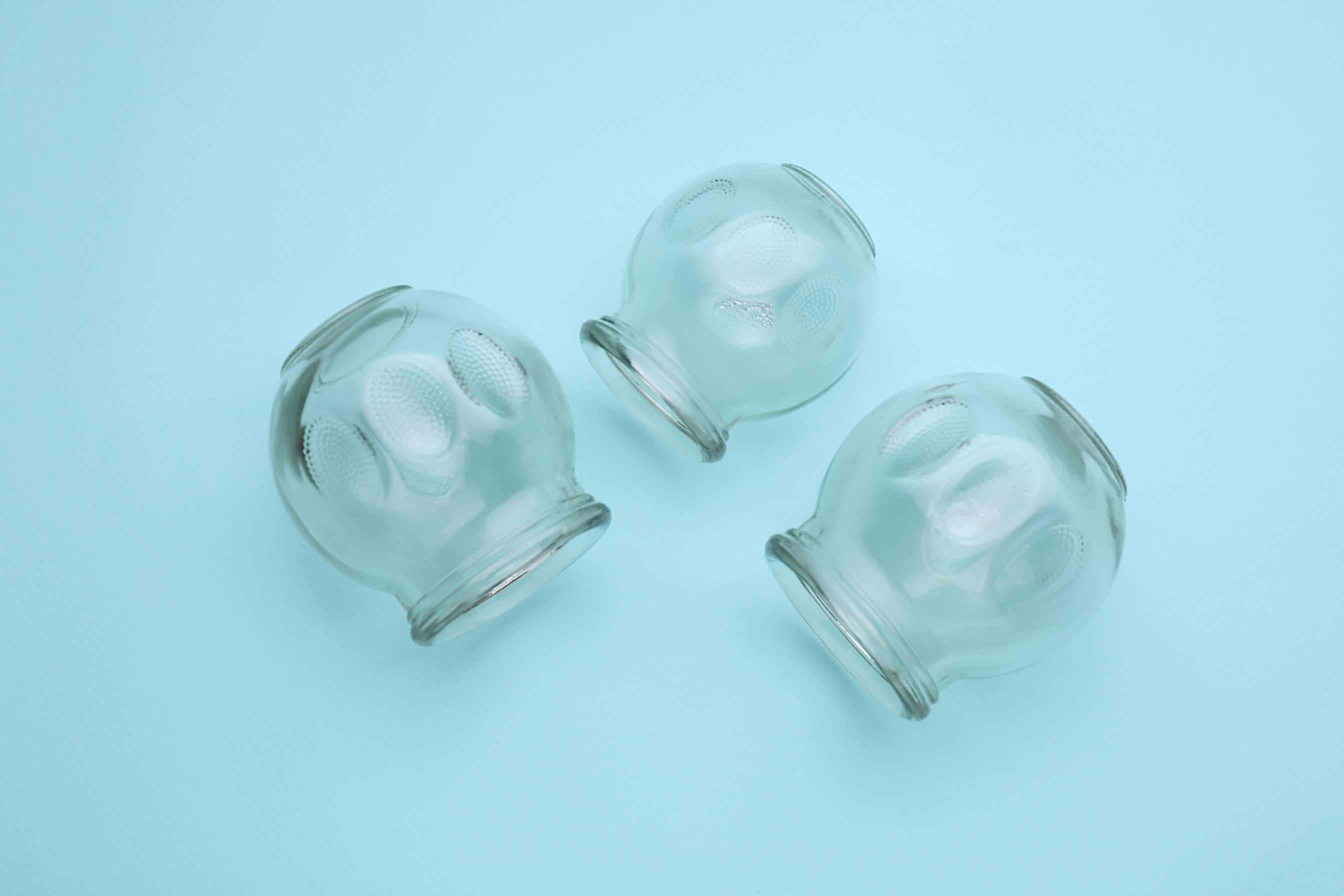 Glass Cups on Light Blue Background, Flat Lay. Cupping